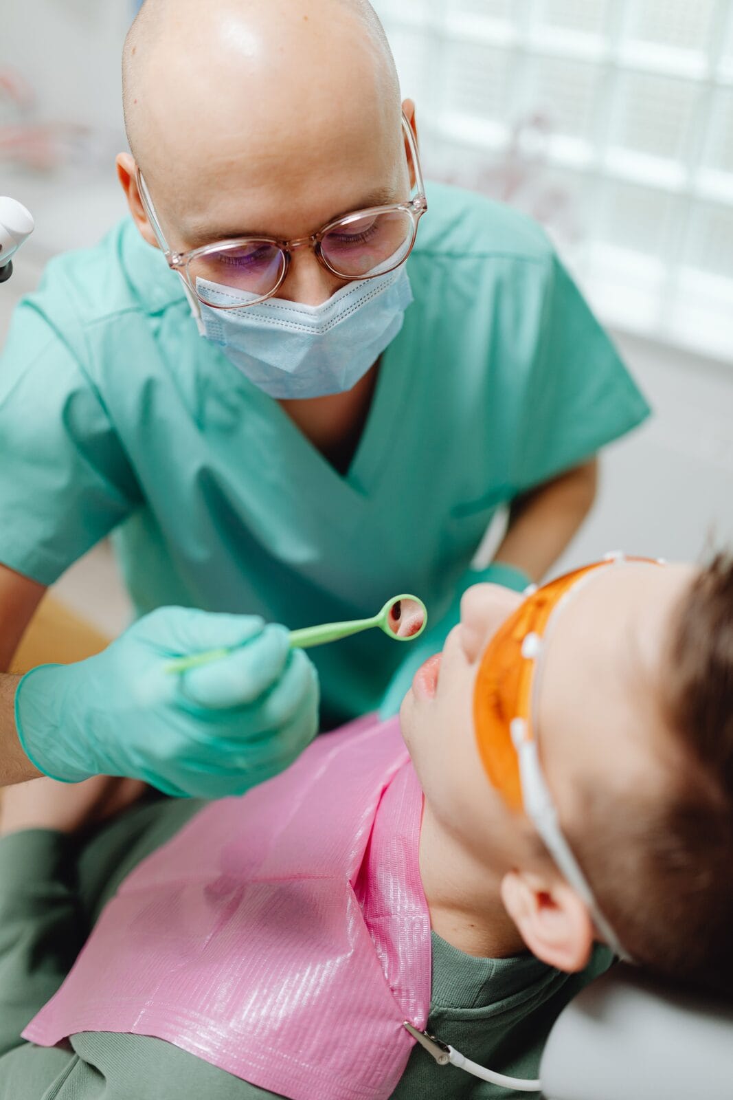 Dentiste examinant les dents d'un enfant lors d'une consultation de pédodontie